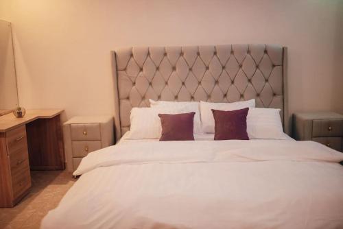 a bedroom with a large white bed with two pillows at Serviced 3Bed Duplex in Oba Akinyele Street, off Rotimi Williams, Bodija in Ibadan