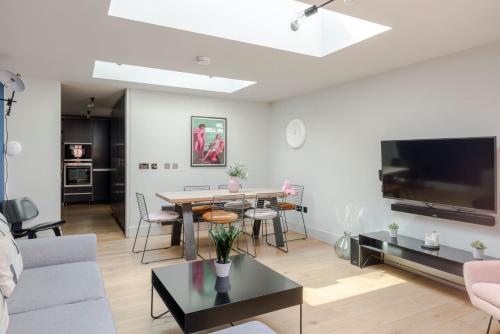 a living room with a couch and a table at Grand Covent Garden 3-bed Penthouse With Terrace in London