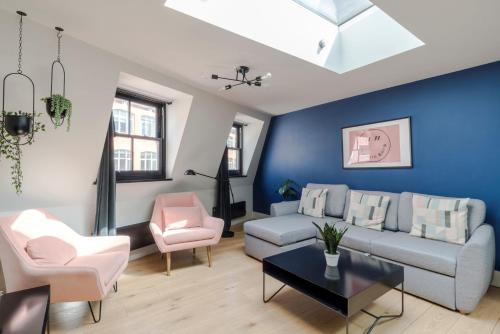 a living room with blue walls and a couch and chairs at The Instagood Apartment - Covent Garden - by Frankie Says in London