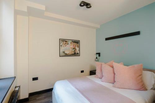 a bedroom with a bed with pink pillows at Vibrant 2-bed Apartment In Soho Near Theatreland in London