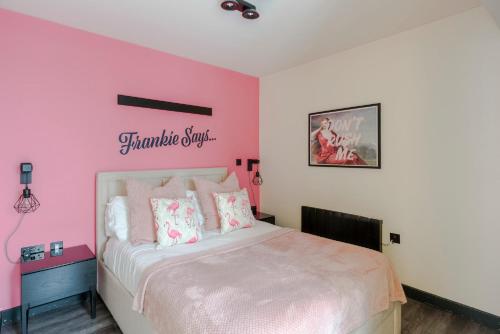 a bedroom with a pink wall with a bed at Vibrant 2-bed Apartment In Soho Near Theatreland in London