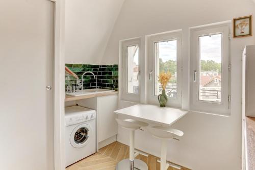 een witte keuken met een wastafel en een wasmachine bij Le Gresset - Vanves in Vanves
