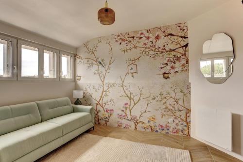 een woonkamer met een bank en een bloemenmuur bij Le Gresset - Vanves in Vanves