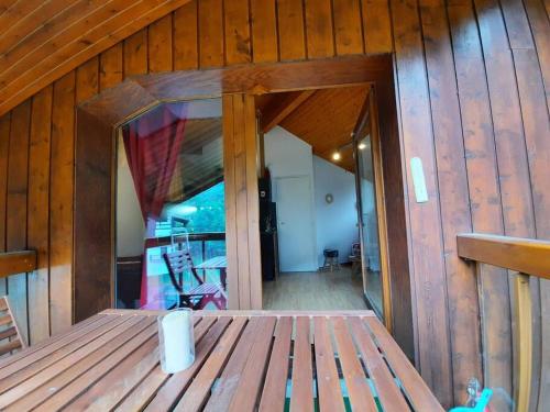 une porte ouverte d'une cabane en bois avec une terrasse couverte dans l'établissement Appartement au pied des pistes, aux Contamines-Montjoie