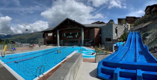 une grande piscine à côté d'un immeuble dans l'établissement La Plagne Appartement au pied des pistes avec vue Mont Blanc, à La Plagne Tarentaise