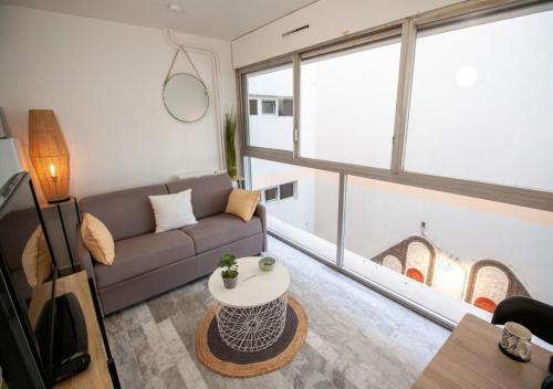 un salon avec un canapé et une table dans l'établissement Stylish Studio with Pool 500 meters to the Beach, à Antibes