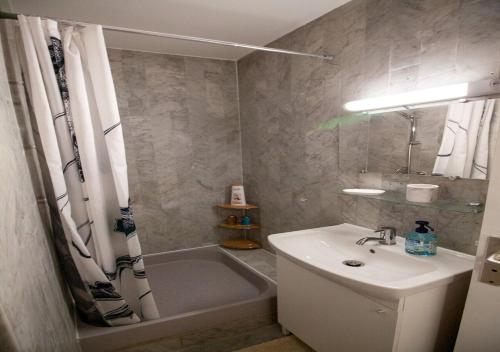 une salle de bain avec un lavabo et une baignoire dans l'établissement Stylish Studio with Pool 500 meters to the Beach, à Antibes