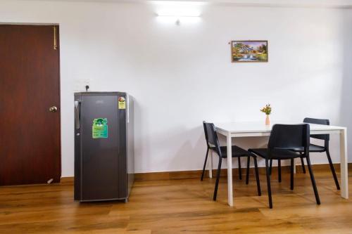 a refrigerator in a room with a table and chairs at Casa Quina in Panaji