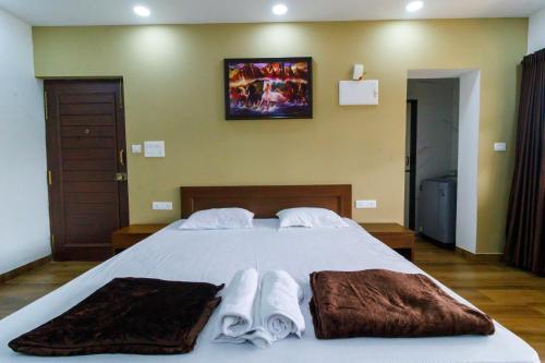 a bedroom with a large bed with towels on it at Casa Quina in Panaji
