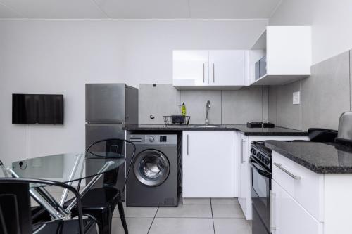 a kitchen with a washing machine and a sink at MINT Express Sandton View in Johannesburg