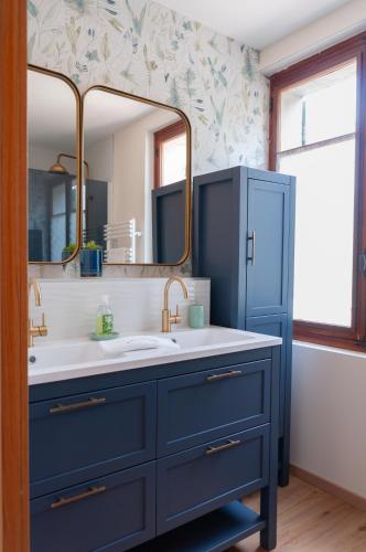 une salle de bain bleue avec un lavabo et un miroir dans l'établissement Vila nostra familha, à Vallon-Pont-dʼArc