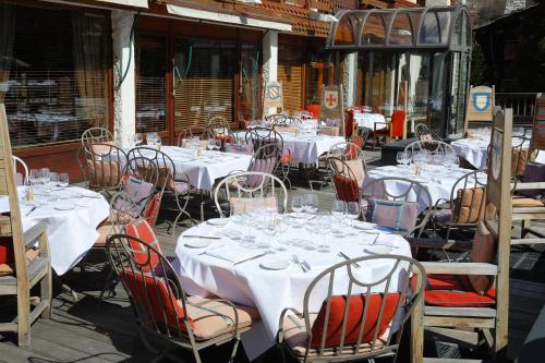 a group of tables with white table cloths and chairs at Hôtel Christiania in Val-d'Isère