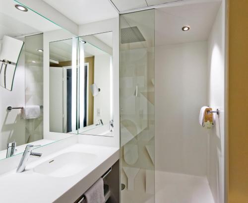 une salle de bain avec un lavabo et une douche dans l'établissement Mercure Rennes Centre Parlement, à Rennes