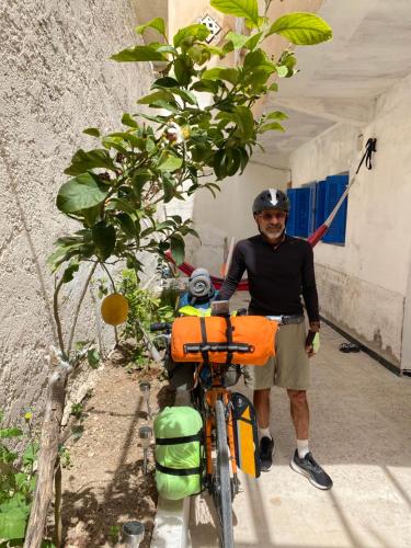 un hombre está de pie junto a una bicicleta en Hostel le Rhumel, en Constantina