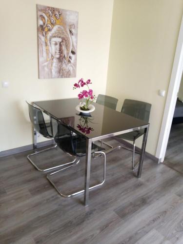 Una mesa de comedor con un jarrón de flores encima. en Lusitaurus, en Montoito