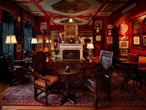 a living room with a fireplace and a table and chairs at The Zetter Marylebone in London