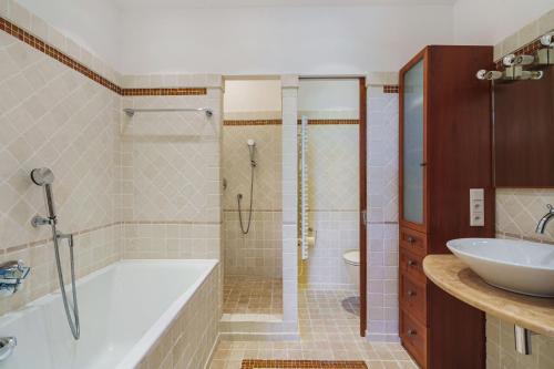 une salle de bain avec une baignoire et un lavabo dans l'établissement Mas de La Tour, à Saint-Tropez