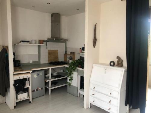 une cuisine avec des armoires blanches et un comptoir dans l'établissement Un petit studio dans un cadre naturel, à Saint-Germain-des-Fossés