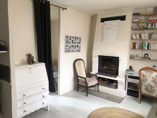 - un salon avec une chaise et une cheminée dans l'établissement Un petit studio dans un cadre naturel, à Saint-Germain-des-Fossés