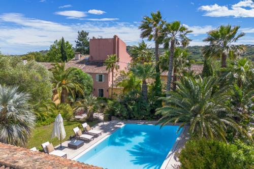 - une vue aérienne sur une piscine bordée de palmiers et une maison dans l'établissement Mas de La Tour, à Saint-Tropez