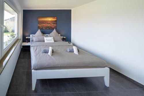 a bedroom with a bed with a painting on the wall at Auszeithaus Wybelsum in Wybelsum