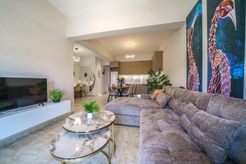 een woonkamer met een bank en twee tafels bij Akalli Luxury Living in Heraklion
