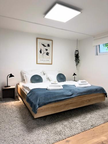 a bedroom with a large bed with a blue blanket at Big Modern Space 75sqm in Herborn