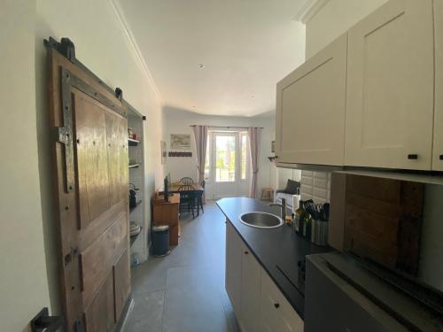 une cuisine avec des armoires blanches et un comptoir noir dans l'établissement Maison du Lac le Studio, à Talloires