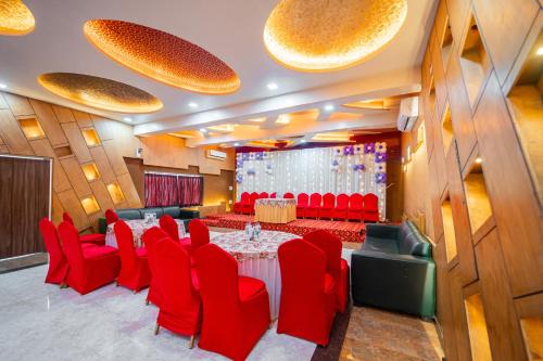 a conference room with red chairs and a long table at Treebo Sai Rekha Inn in Nashik