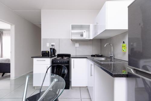 a white kitchen with a stove and a sink at MINT Express Sandton View in Johannesburg
