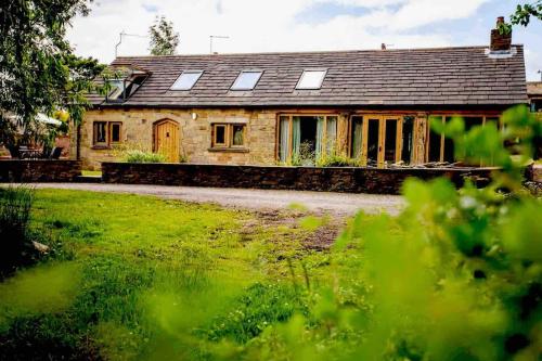 an old stone house with windows and a yard at Four bed barn conversion Junction 37 38 M1 in Barnsley