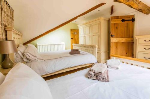 a bedroom with two beds with towels on them at Four bed barn conversion Junction 37 38 M1 in Barnsley