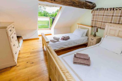 a bedroom with two beds and a window at Four bed barn conversion Junction 37 38 M1 in Barnsley
