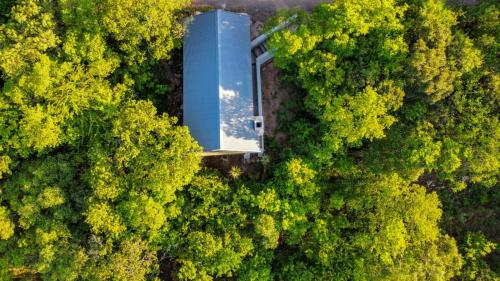 an overhead view of a blue building in the middle of a forest at Matatane Camp - Babanango Game Reserve in Nkwalini