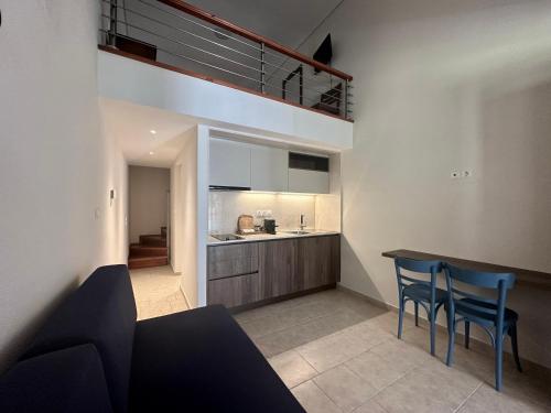 a kitchen with a table and chairs in a room at Zouzoulas Filoxenia - Koralia Apartments in Mil&iacute;na