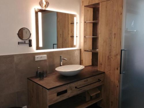 a bathroom with a sink and a mirror at Rabenstein Suiten in Zwiesel
