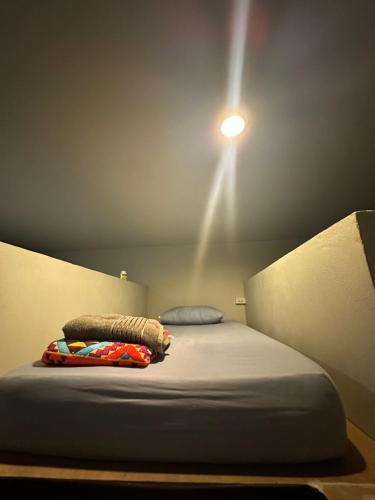 a bed in a room with a light on the ceiling at Noahs Ark in Amphoe Koh Samui