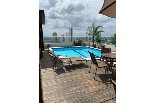 a deck with a swimming pool and a table and chairs at Studio Sublime West Flat Mossoró in Mossoró