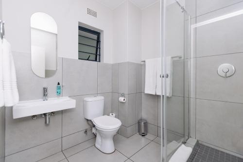 a bathroom with a toilet and a sink and a shower at MINT Express Sandton View in Johannesburg