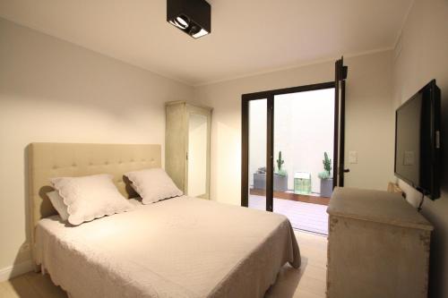 une chambre avec un lit et une grande fenêtre dans l'établissement CALVI Centre ville Vue Mer au Calme, à Calvi