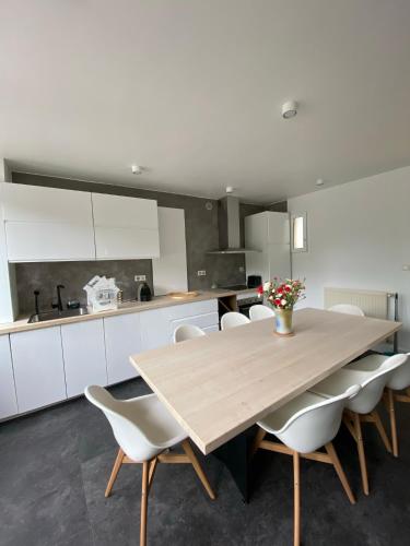 une cuisine avec une table en bois et des armoires blanches dans l'établissement Villa & Appartments des Muriers - 500 m du Lac, à Annecy