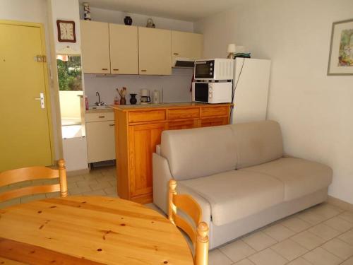 un salon avec un canapé et une cuisine dans l'établissement Bel appartement climatisé 100m plage, à Cavalaire-sur-Mer