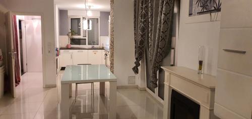 a white kitchen with a table and a fireplace at Urlaubsfeeling wahrnehmen Perfekte Outdoor nur langzeit Vermietung! in Hamburg