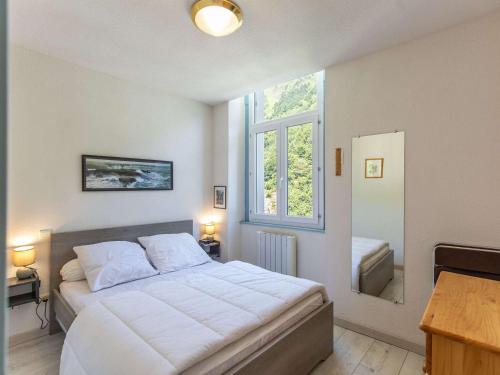 une chambre avec un grand lit blanc et une fenêtre dans l'établissement Appartement cosy 5 pers avec mezzanine et équipements à Barèges - FR-1-403-49, à Barèges