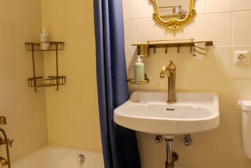 a bathroom with a sink and a shower with a tub at VILLA OXA - Boutique Design Hotel in Maria Alm am Steinernen Meer