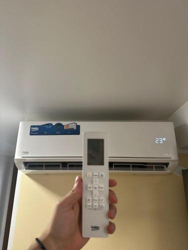a person holding a remote control in front of an appliance at Casa Tudor in Tîrgu Ocna
