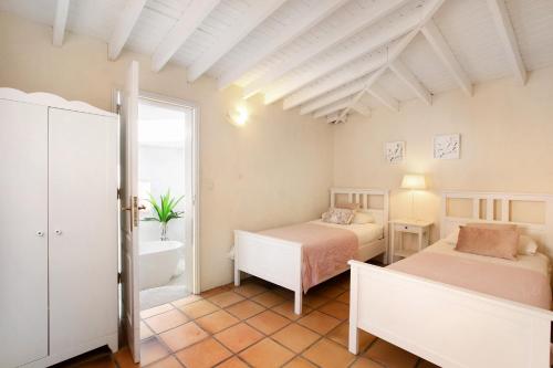a bedroom with two beds and a tub and a window at Saint Maxime in Adeje