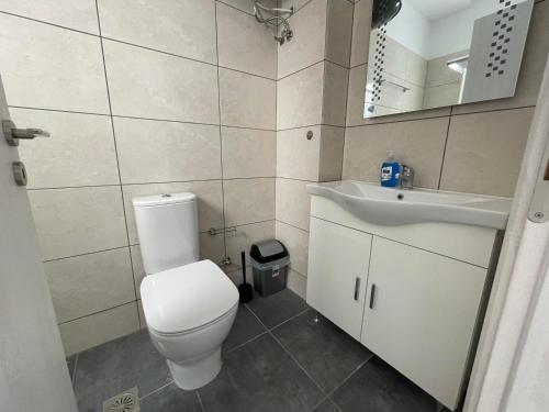 a bathroom with a white toilet and a sink at Vibrant Omonia Oasis, Modern Apartment in the Heart of Athens in Athens