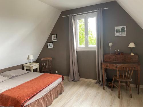 a bedroom with a bed and a desk and a window at Apple garden in Victot-Pontfol