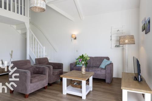 a living room with two couches and a tv at OV072 Exklusives 4P-Ferienhaus in bester Lage in Giethoorn in Giethoorn